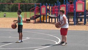 Two boys have fun playing basketball.