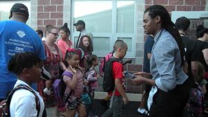 A student ready for her high-five as she enters the school.