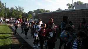 Students walking into the school to the sounds of cheers and encouragement.