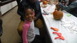 A student smiles after she finishes her pumpkin.