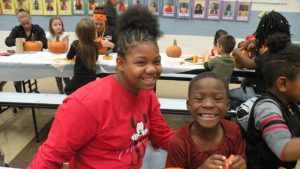 A student and his middle school helper smile for the camera.