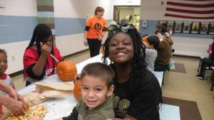 A student and his middle school helper smile for the camera.