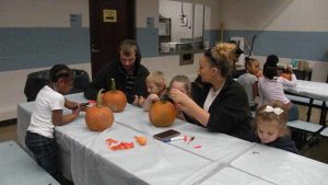 A family working together on their pumpkins.