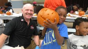 A student and his helper show off their finished pumpkin.