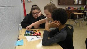 Two students and their mentor play a fun game.