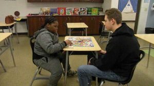 A third grader plays a game with his mentor.