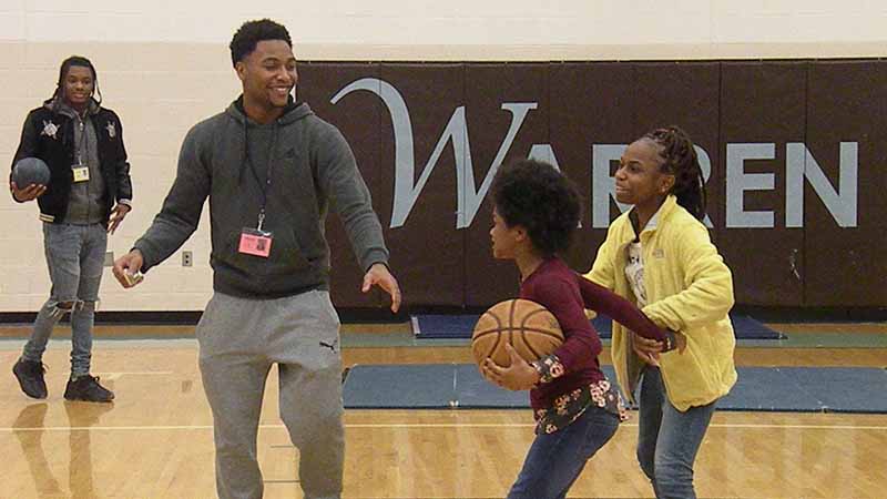 Harding student plays in the gym with 3rd graders,