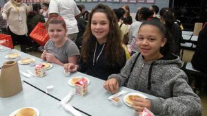 Three fifth grade students smile for a quick picture.