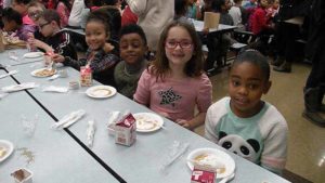 Second graders take a break from their pancakes for a quick picture.