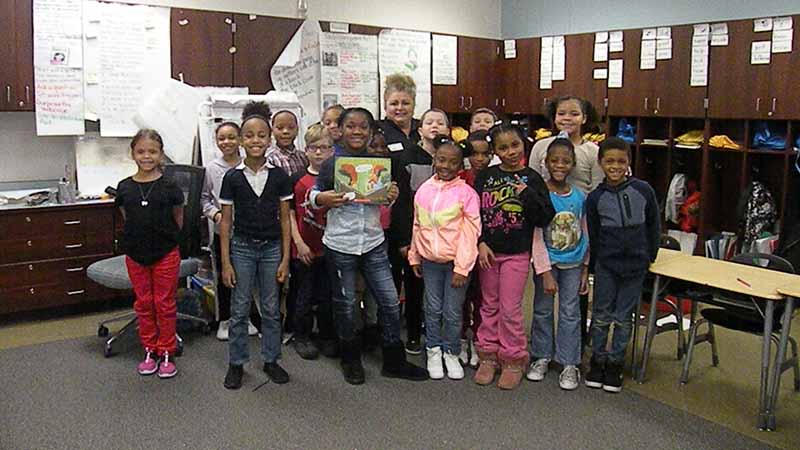 A class takes a picture with their guest reader.