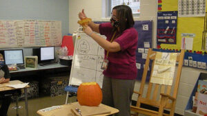 Mrs, Haswell shows seeds under the stem of the pumpkin