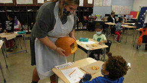 A student gets to look inside the pumpkin