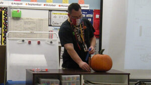 Mr. Bitner models how to find the height of the pumpkin