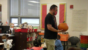 Mr. Bitner walks around to show the pumpkin