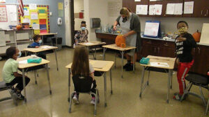 Students watch as their pumpkin is scooped out
