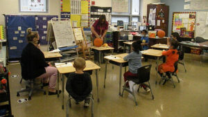 Students watch as Mrs. Haswell begins to scoop out the pumpkin