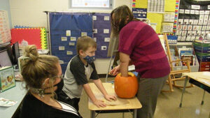 Mrs. Haswell scoops out seeds for her students