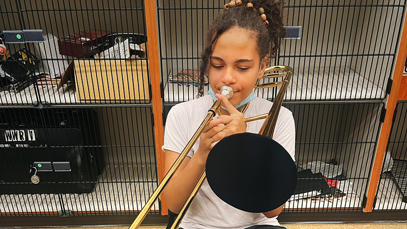 An eighth grade student tries out her trombone.