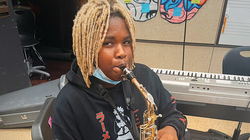 An eighth grader is excited to start playing his saxophone.