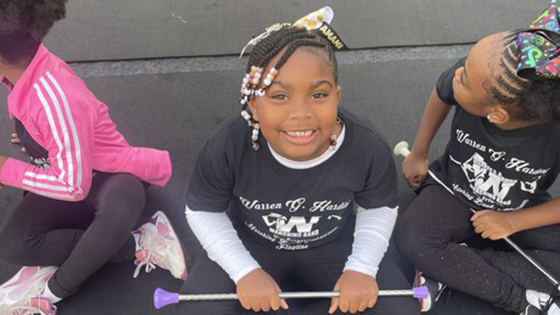 Jefferson student sitting with her baton waiting to perform.