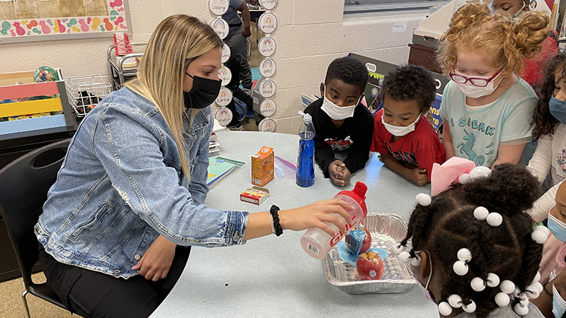 Miss Price pours the vinegar over the apples.