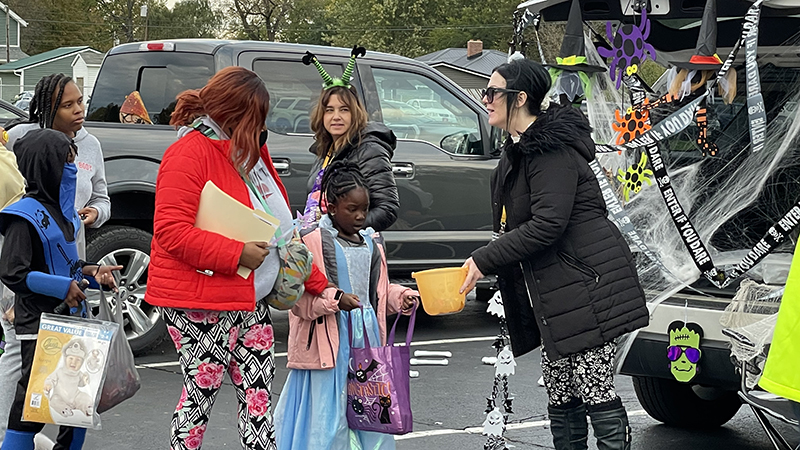 Fifth grade teachers pass out candy to families.