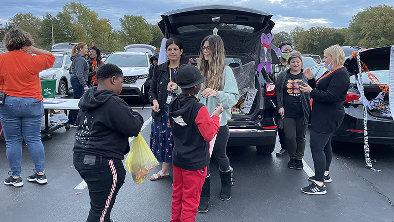 Third grade teachers passing out candy.