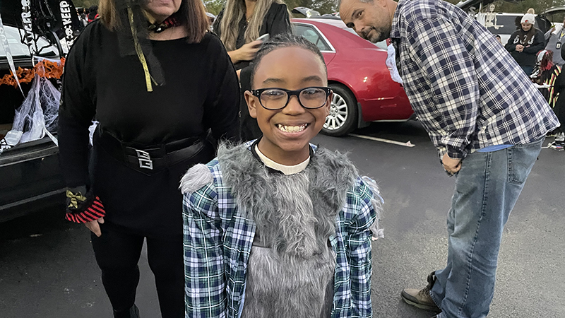 Student smiles as he enjoys trunk or treat