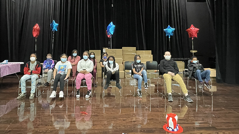 students sitting on stage as they wait to begin the geography bee.