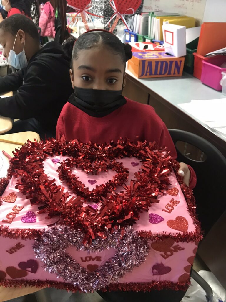 A student shows her beautiful, homemade valentine box.