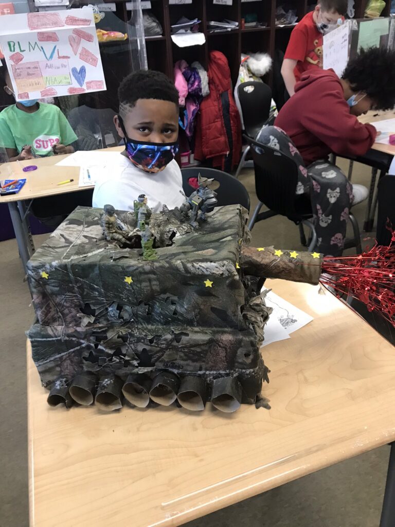 A student sits with his home made box.