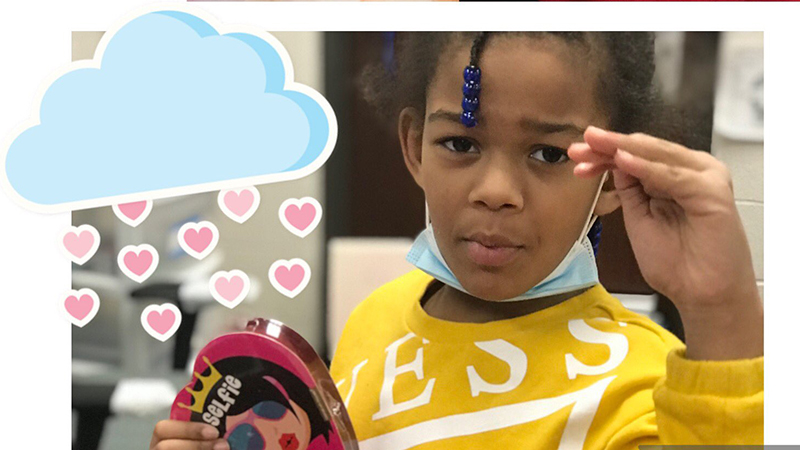 Student holds her valentine a rain drop cloud emoji on the side.