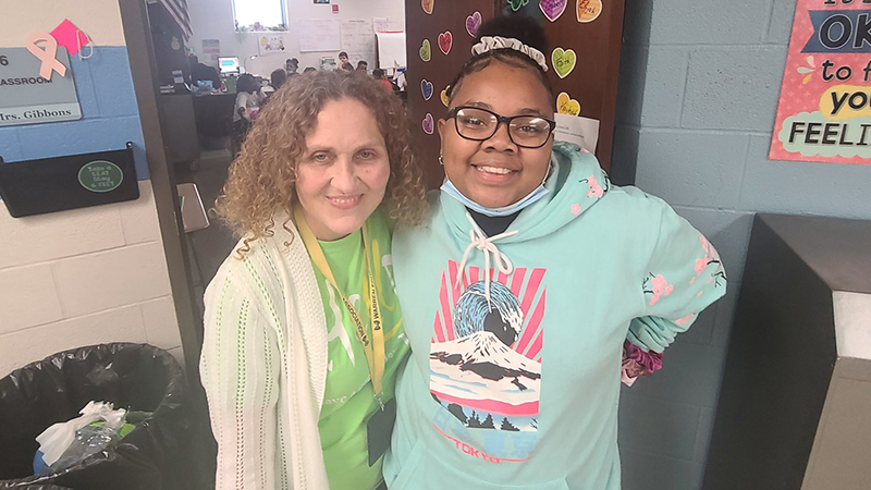 Student stands next to her former third grade teacher.