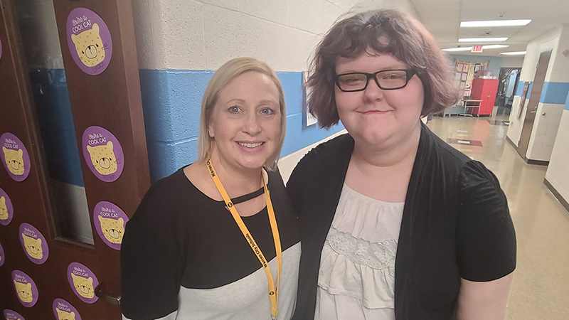 Student stands next to her former third grade teacher.