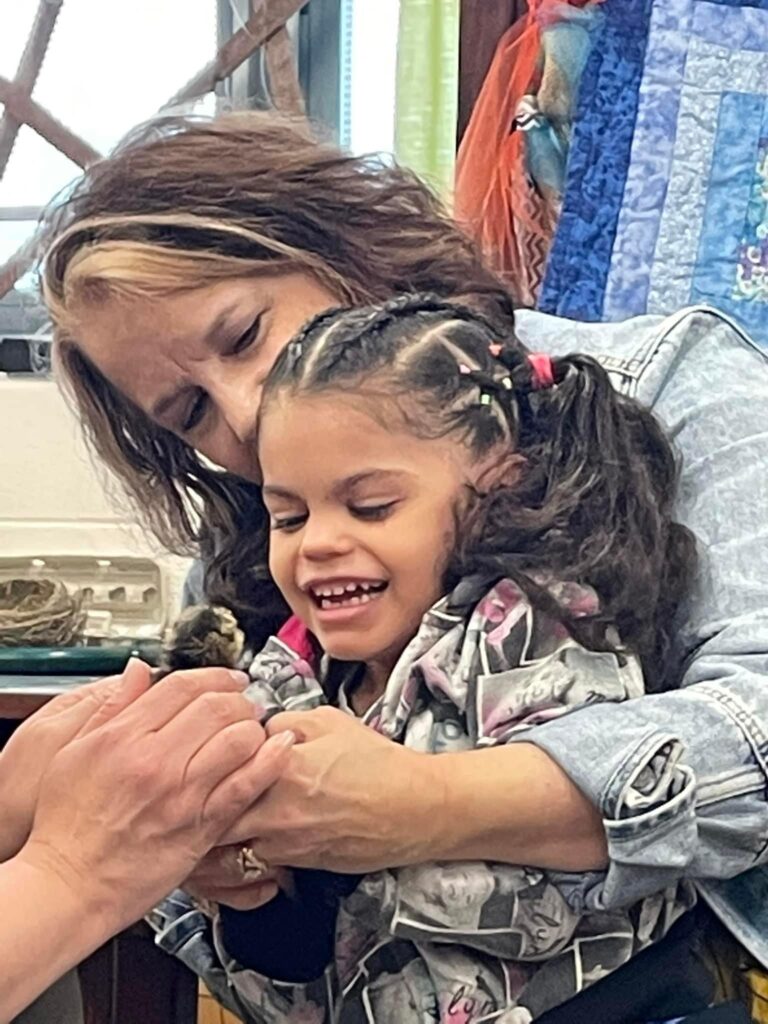 Mrs. Roberts and a student hold a baby chick.