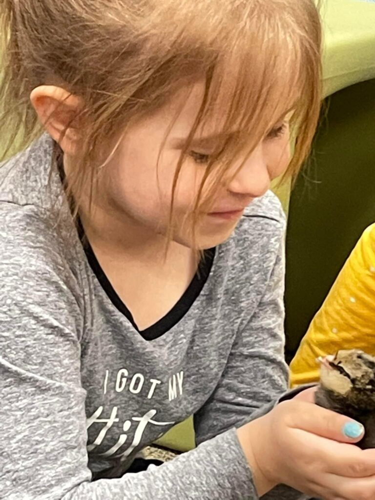 A student holding the baby chick.