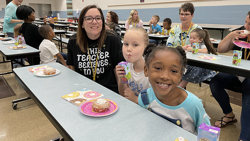 First graders enjoy their donut award with Mrs. Haswell.