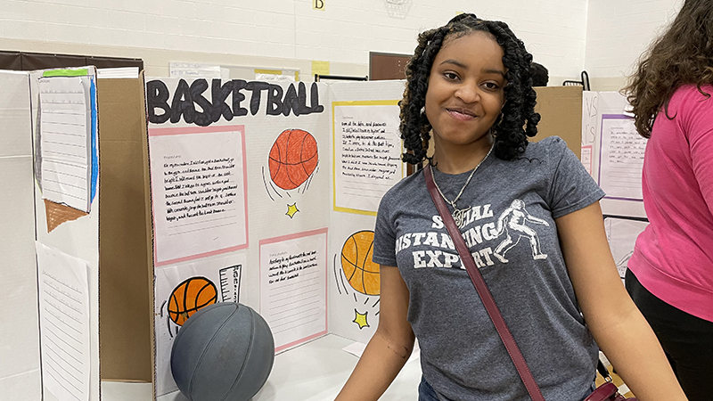 A student with their project about basketball.