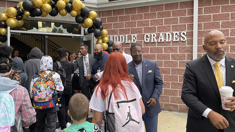 greeting students as they enter the school