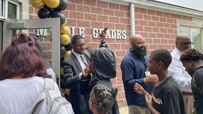 greeting students as they enter the school