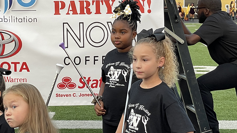 Three students listen to directions before their performance.