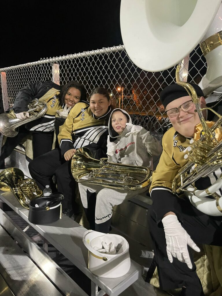 A baritone player from Jefferson poses for a picture while they sit in the stands with Harding band students.