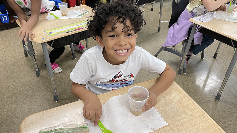 A first grader enjoying his apple pie treat.