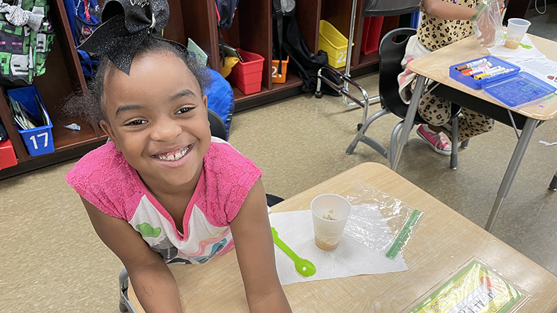 A first grader enjoying her apple pie.