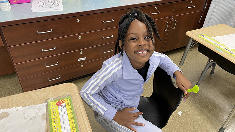 A student smiles after she finishes her treat.