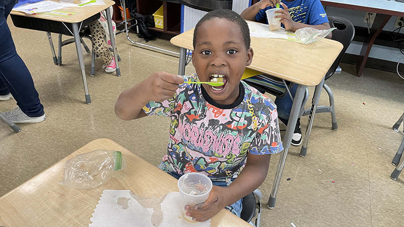 A student takes a bite of his apple pie.