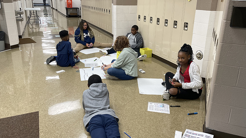 A group of fifth graders coding their paths for their robots.