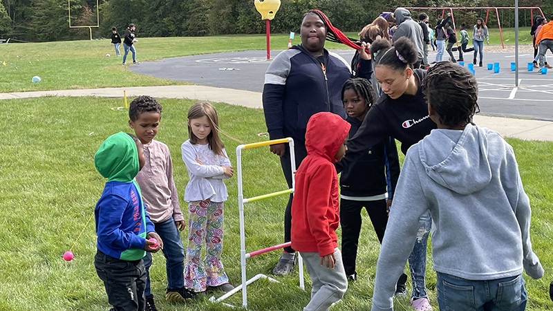 Eighth graders helping younger students learn a new game.