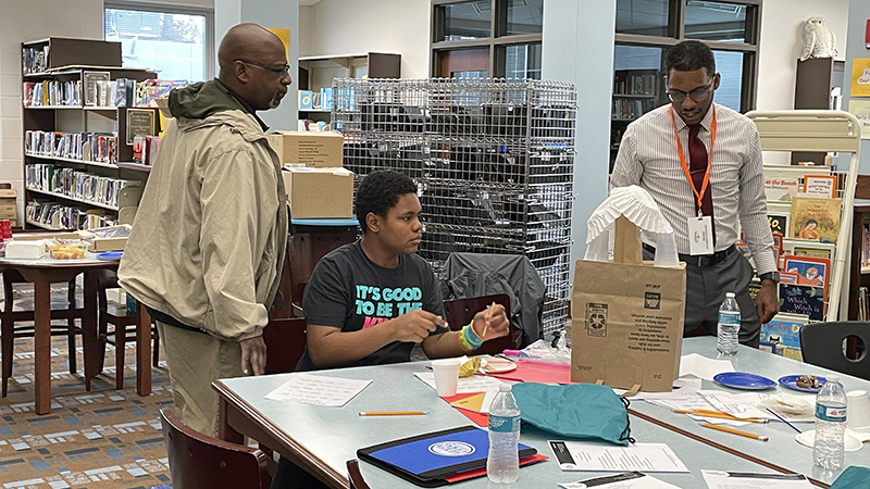 A student and his mentor talk about their building project.