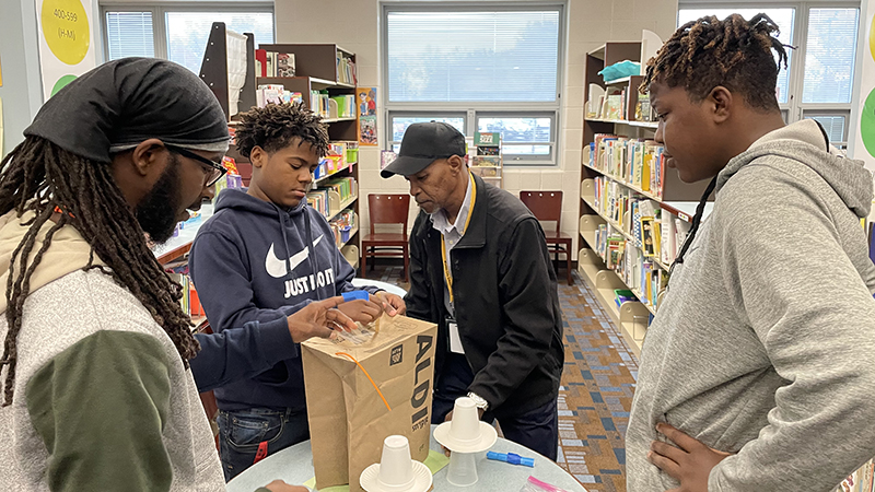 Students and their mentors work on a stem challenge.